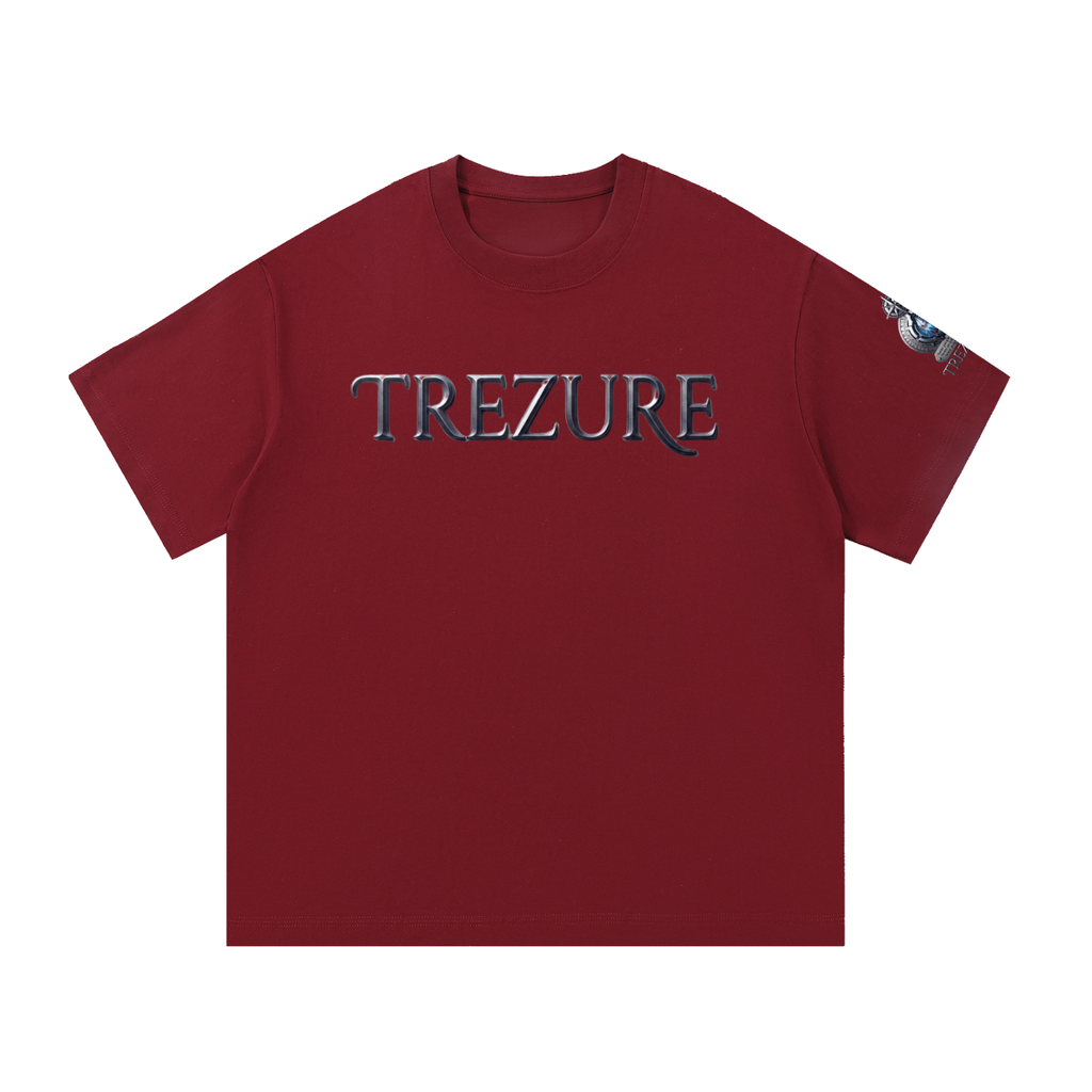 A dark red crewneck t-shirt featuring the word 'TREZURE' printed across the chest in a stylized metallic silver and blue font. A small graphic is visible on the right sleeve.